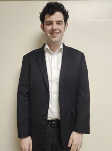 oliver moore wearing a suit and smiling
